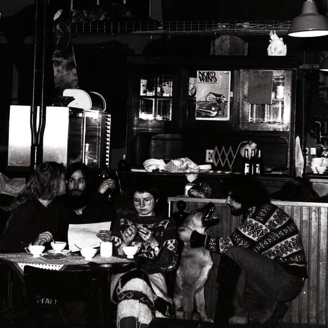 Mehrere Personen sitzen in einem Cafébereich des Kulturzentrums Pumpwerk in den 1990ern.