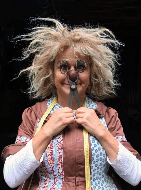 Die clowneske Figur Gardi Hutter war die Gewinnerin des Kleinkunstpreises Knurrhahn im Jahr 1986. lt eine große Schere vor das Gesicht, ein Maßband hängt um den Hals.