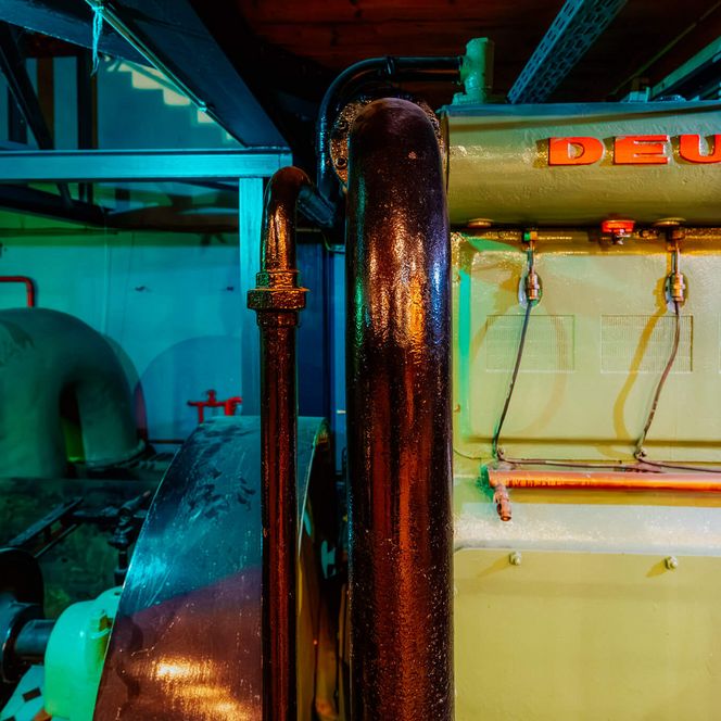 Alte Deutz-Pumpe mit Rohrleitungen und Maschinenbauteilen im Inneren des Kulturzentrums Pumpwerk.